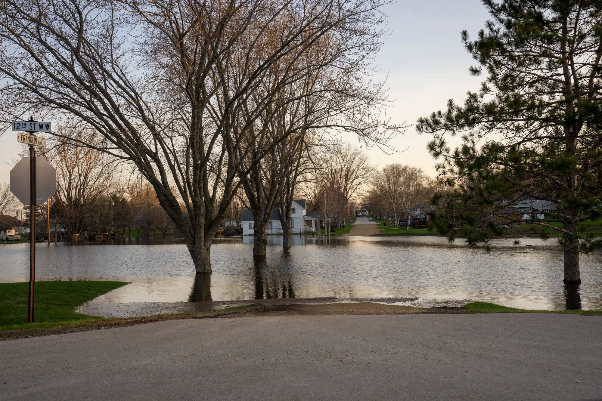 A residential street in spring flood, the water stopping at the edge of the road